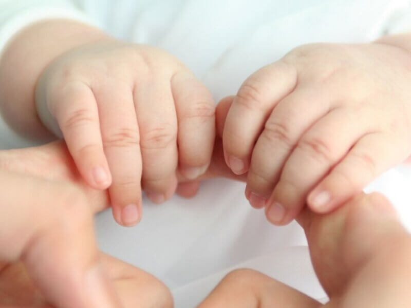 赤ちゃんの手を握るママ